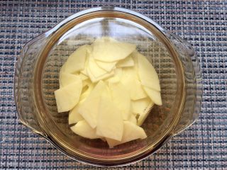 2、香烤芝士土豆泥炒饭,将土豆切薄片，盖上盖子用微波炉加热8分钟。（也可以用蒸的方法，只要把土豆变软可以做成土豆泥）