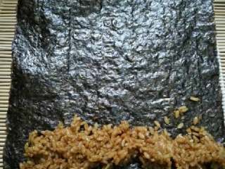 1、小熊寿司卷,取一张海苔，铺上酱油饭，条要稍微细一点。