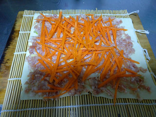 9、美容养颜豆皮蔬菜肉卷—送给美丽的女神们,将胡萝卜丝均匀散在肉馅上，然后压一压。