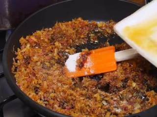 9、自制XO瑶柱酱,倒入洋葱碎，炸至浅金色，在另一锅里倒入料酒、生抽、蚝油、糖和汤汁，搅拌均匀