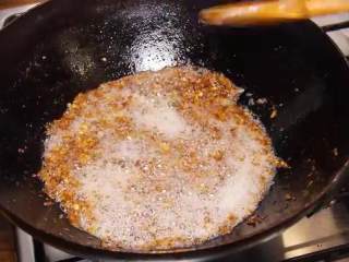 10、自制XO瑶柱酱,蒜末倒入油锅里，再炸7-8分钟直至都呈焦黄色