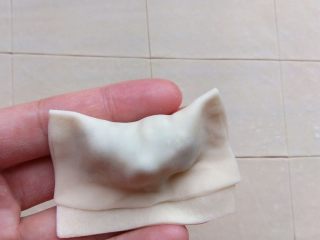 9、家常三鲜小馄饨,将面片翻起，包住馅料，边缘捏合。