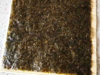 6、紫菜包饭,把紫菜铺在帘子上。