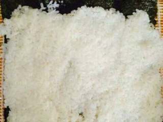 3、紫菜包饭,在竹帘上铺一张紫菜，然后将米饭均匀的铺在紫菜上