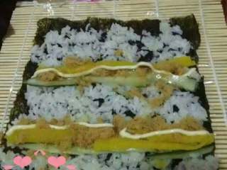 2、美味寿司,把海苔放到卷帘上面，一次放好米饭，黄瓜条，肉松，练奶