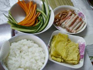 3、自制寿司,准备所有辅料:胡萝卜、黄瓜、蟹足棒、火腿肉、鸡蛋饼切成长条形