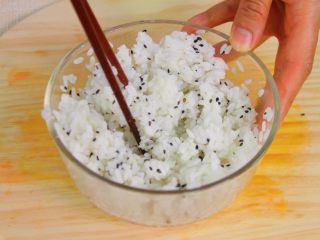 1、自制寿司,稍微放温加入寿司醋和炒香的芝麻拌匀。