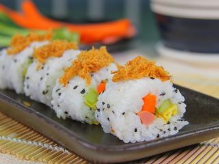 4、自制寿司,卷起，借助帘子压紧定型，切成小段，然后撒点肉松营养更均衡了。