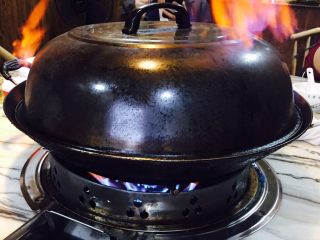 8、火焰醉鹅,盖上盖子,用火枪在盖子四周点上火