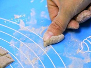 4、花样猫耳朵,面板上撒干面粉，取一个面丁用大拇指的指腹外侧缘向前压撵面丁，即成光面的猫耳朵。这款是最家常版本的。