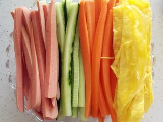 2、紫菜包饭,摊好的蛋皮 胡萝卜 黄瓜 火腿肠（在摊鸡蛋的锅里稍微过下）切条备用 ... 