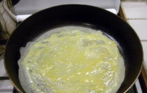 2、三色蛋卷,平底锅放火上烧热，用喷壶将油均匀在锅底喷一层（或者倒入适量油，转动锅让油均匀布满锅底，再将多余的油倒出），转小火，倒入适量蛋液在锅中，转动锅让蛋液均匀布满锅底。