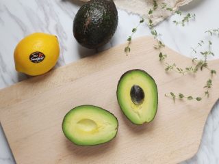 1、牛油果冰淇淋,选表皮呈黑色熟透的牛油果三个，纵向对半切至果核处，双手拧开。