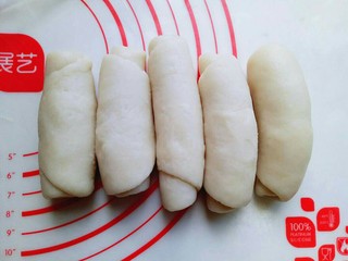 10、蛋黄酥,全部做好后用保鲜膜盖上，松弛15分钟，之后再取一块面团，面团竖着用擀面杖来回擀的长舌状，这样反复两次。就是:擀长舌状再卷起来，再擀长舌状，卷起来，同样操作方法。