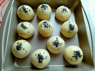 16、蛋黄酥,刷好蛋液的蛋黄酥上面撒上撒上黑芝麻，撒好芝麻后还可以再刷一层蛋液。