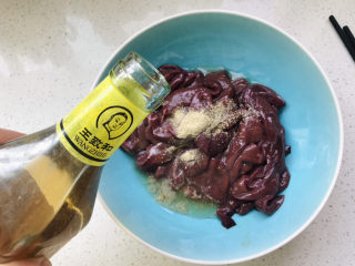 10、洋葱炒猪肝,倒入适量料酒;