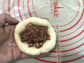 6、叉烧面包,取一个松弛好的面团，擀开边上的气泡拍掉，翻面，码适量的叉烧肉