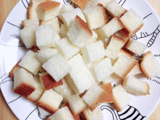 2、鸡蛋牛奶布丁,先将切片面包切成小块。