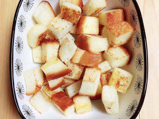 10、鸡蛋牛奶布丁,将香煎好的面包块放入烤碗中。