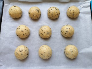 7、麦片芝麻小餐包,烤盘里铺上油纸，将面包面团滚圆放在油纸上。