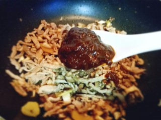 13、香菇肉丝炸酱面,加入一勺豆瓣酱。翻炒均匀。