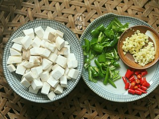 2、宫保杏鲍菇,杏鲍菇切成丁，因为炒的过程中会缩小 ，可以切到1.5厘米左右。切好青椒和辣椒，蒜和姜剁碎备用。