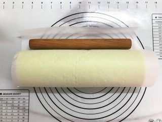 14、草莓斑斓蛋糕卷,借助擀面杖将蛋糕卷起来，用油纸卷起来放入冰箱冷藏定形30分钟。