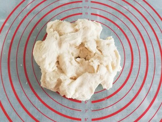 4、蔓越莓手撕小面包,接着把面团用手撕着小块，再盖上保鲜膜静置10分钟左右；