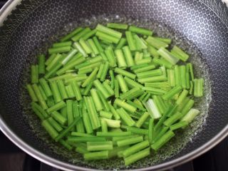 4、香干炒芹菜,锅中倒入适量的清水烧开后,加入少许盐,把芹菜进行焯水,看见芹菜变色捞出过冷水后沥干。