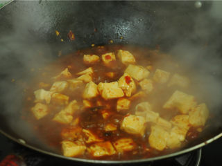 9、红烧豆腐,烧开后放入豆腐、大火烧煮一分钟，为了避免糊锅，中间适度旋转锅身，取一半水淀粉勾芡，继续旋动锅身烧煮大约一分钟，再放剩下的水淀粉，
