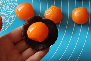 5、蛋黄酥,将分割好的豆沙揉圆按扁，放上蛋黄