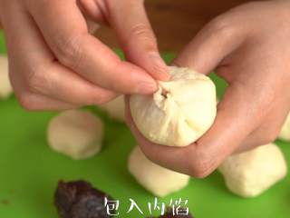 7、奶香心形【红豆面包】柔软甜蜜,将小面团整形变圆，红豆沙分成15g每个，并搓圆。取一个面团压扁，包入内馅