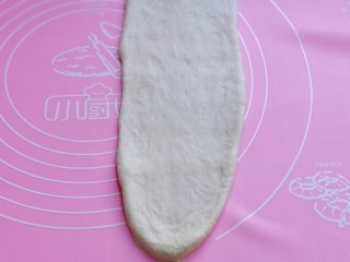 14、中种豆沙吐司面包,取一块面团，用擀面杖擀开，将气泡拍破。