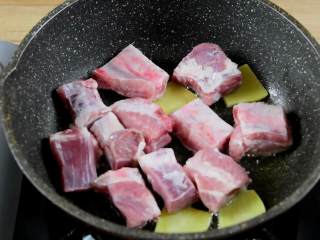 1、柚香排骨,这道甜蜜柚子香味的排骨你试过吗,热锅冷油,放入姜片、排骨,小火将排骨煎至两面金黄。