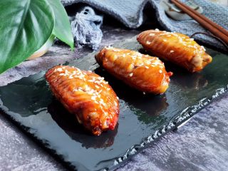 7、空炸蜜汁鸡翅,取出，炒面撒适量白芝麻即可
