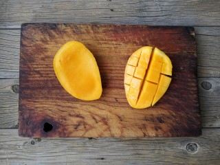 6、芒果黑糯米甜甜——夏日里的清凉甜意,芒果对剖切成两片,将其中一片切成格子,剔下果肉。