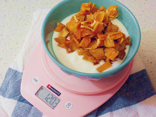 2、制做简单快捷的下午茶点心【酸奶芒果干麦芬】,称取225克酸奶，将切好的芒果丁放入酸奶中