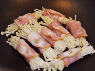 10、金针菇培根卷,锅中放少许油烧热,小火放入培根卷。