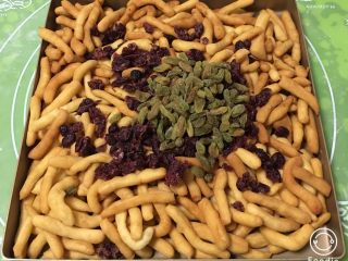 14、蔓越梅沙琪玛,放入蔓越梅和葡萄干，翻拌均匀。