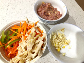 3、鱼香肉丝,准备蔬菜：青红甜椒、胡萝卜、笋切丝。姜和大蒜切碎。备用。