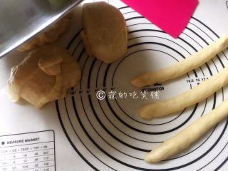 7、一发的淡奶油辫子面包,称一下面团的实际重量，平均分成四份（也可以分成你想要做的份数），去一个团再平均分成三份，分别揉圆后搓成长条（另外暂时没用到的三个面团，用盆或者保鲜膜盖起来以防表皮吹干）。
