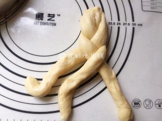 9、一发的淡奶油辫子面包,然后就像麻花辫一样把它编起来，记得编紧一点，底部尽量编到不能编的程度，也捏紧捏牢。