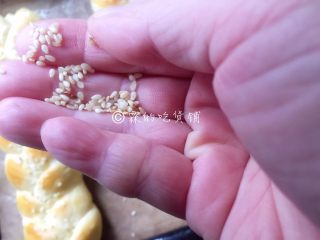 12、一发的淡奶油辫子面包,趁面包表面有一点潮湿时，快速的撒上芝麻。