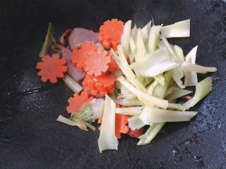 8、胡萝卜炒腊肉,加入西芹和胡萝卜片进行翻炒