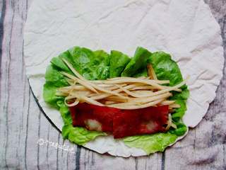 8、酸辣土豆丝卷饼,取一张烙好的面皮，中间放上土豆丝、培根和生菜