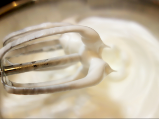 8、酸奶戚风纸杯蛋糕,用打蛋器打至粗鱼眼泡,加第一次糖,打至泡沫细腻,加第二次,再打至稍稠即湿性发泡状态,可拉出大弯勾加第三次糖,最后打至9分发,提起打蛋器头呈小三角;