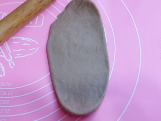 11、吃一次就会爱上它的美~可可酸奶面包,取一块面团,用擀面杖擀长舌状。