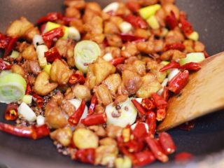 12、辣子鸡丁,调大火，放入鸡块翻炒均匀。