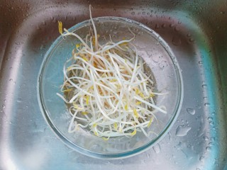 2、猪油拌面,将豆芽放入碗里,加满水用手轻轻搅动,没有脱落的豆芽皮就漂浮在水面上,然后用手捞出,豆芽的根本也可以择去。