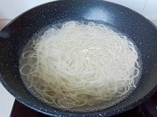 4、猪油拌面,锅里加盐,水开下入面条开大火煮。